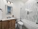 Contemporary bathroom with a wood vanity, glass shower door, and grey mosaic floors at 18577 Clay Hill Rd, Dade City, FL 33523