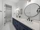 Chic bathroom with double vanity, herringbone tile floors, and modern fixtures at 18577 Clay Hill Rd, Dade City, FL 33523