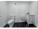 Modern half bathroom featuring black epoxy floors, white walls, and sleek vanity at 18577 Clay Hill Rd, Dade City, FL 33523
