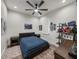 This bedroom is spacious, and features wood floors, a ceiling fan and large windows at 18577 Clay Hill Rd, Dade City, FL 33523
