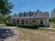 Stunning farmhouse with covered porch, dormer windows, and professionally landscaped yard at 18577 Clay Hill Rd, Dade City, FL 33523