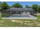 Aerial view of a modern farmhouse highlighting its screened-in pool and backyard at 18577 Clay Hill Rd, Dade City, FL 33523