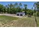 Exterior view of a detached garage with a gravel parking area at 18577 Clay Hill Rd, Dade City, FL 33523