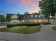 Stunning home exterior showcases a manicured lawn, elegant landscaping, and a charming facade under a colorful sunset sky at 18577 Clay Hill Rd, Dade City, FL 33523