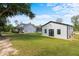 Exterior view of a modern farmhouse with a large yard and additional outbuilding at 18577 Clay Hill Rd, Dade City, FL 33523