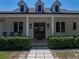 Welcoming front porch with rocking chairs, double glass doors and manicured hedges at 18577 Clay Hill Rd, Dade City, FL 33523
