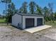 Metal building with two roll-up doors and concrete slab for parking or workshop on a rural property at 18577 Clay Hill Rd, Dade City, FL 33523
