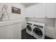 Laundry room features modern appliances, ample storage, and stylish black tile flooring at 18577 Clay Hill Rd, Dade City, FL 33523