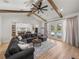 Open-concept living room features a large sectional, wood beams, and seamless flow to the inviting outdoor pool area at 18577 Clay Hill Rd, Dade City, FL 33523