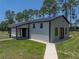 Exterior shot of a large white outbuilding with black trim and a concrete pathway at 18577 Clay Hill Rd, Dade City, FL 33523