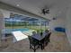 Spacious covered patio with outdoor dining, a built-in grill, and a view of the screened-in pool at 18577 Clay Hill Rd, Dade City, FL 33523