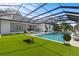 Screened-in pool with lounge area and outdoor dining space at the back of the house at 18577 Clay Hill Rd, Dade City, FL 33523