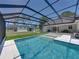 A stunning backyard featuring a pool with a screened enclosure and a covered patio at 18577 Clay Hill Rd, Dade City, FL 33523