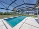 Beautiful in-ground pool with a screen enclosure and well-manicured lawn for summer relaxation at 18577 Clay Hill Rd, Dade City, FL 33523