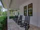 Relaxing front porch with black rocking chairs and views of the landscaped garden at 18577 Clay Hill Rd, Dade City, FL 33523