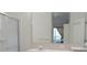 Bright bathroom featuring double sinks, vanity with a mirror, glass-enclosed shower and view from window at 1922 Sassafras Dr, Wesley Chapel, FL 33543