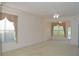 Bright and airy living room with neutral carpet, ceiling fan, and large windows with scenic views at 1922 Sassafras Dr, Wesley Chapel, FL 33543
