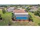 Aerial view showcasing home with a screened-in pool in landscaped yard at 202 Grayson Ct, Sun City Center, FL 33573