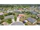 Expansive aerial view showcases a single-Gathering home with solar panels and a well-manicured lawn in a lush community at 202 Grayson Ct, Sun City Center, FL 33573