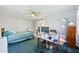 Bedroom features blue carpeting, a ceiling fan, desk and a view to the outside at 202 Grayson Ct, Sun City Center, FL 33573
