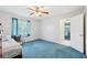 Bedroom with blue carpeting, a ceiling fan and a window overlooking the yard at 202 Grayson Ct, Sun City Center, FL 33573