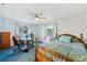 Bedroom features blue carpeting, a ceiling fan, desk and a view to the outside at 202 Grayson Ct, Sun City Center, FL 33573