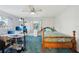 Bedroom features blue carpeting, a ceiling fan, desk and a view to the outside at 202 Grayson Ct, Sun City Center, FL 33573