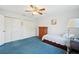 Bedroom with blue carpeting, a ceiling fan and a dresser next to the bed at 202 Grayson Ct, Sun City Center, FL 33573