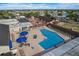 Inviting aerial view showcases a community pool area with lounge seating and umbrellas, set against a charming community backdrop at 202 Grayson Ct, Sun City Center, FL 33573