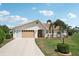 Inviting single-Gathering home with a green lawn, palm trees, and a warm, welcoming facade at 202 Grayson Ct, Sun City Center, FL 33573