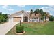 Charming single-story home showcasing a well-manicured lawn, lush landscaping, and a two-car garage at 202 Grayson Ct, Sun City Center, FL 33573