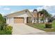 Welcoming home with a manicured lawn, established landscaping, and a convenient two-car garage at 202 Grayson Ct, Sun City Center, FL 33573