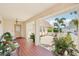 Charming porch with potted plants, tile flooring, and an ornate gate, creating a welcoming entrance at 202 Grayson Ct, Sun City Center, FL 33573