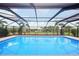 Stunning view of the enclosed pool featuring an elegant patio and surrounding greenery at 202 Grayson Ct, Sun City Center, FL 33573