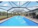 An enclosed swimming pool, with tile trim, sits at the center of the fenced-in backyard at 202 Grayson Ct, Sun City Center, FL 33573