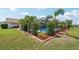 Landscaped backyard with a screened-in pool and lush green grass at 202 Grayson Ct, Sun City Center, FL 33573