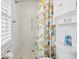 White tiled shower with a colorful fish-themed curtain and built in shelves at 202 Grayson Ct, Sun City Center, FL 33573