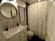 Well-lit bathroom with a marble countertop, round mirror, and patterned shower curtain, exuding style and elegance at 21103 Patio View Ct # 3302, Lutz, FL 33558