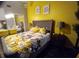 Bright bedroom with a yellow accent wall and floral bedding, offering a cheerful and inviting space at 21103 Patio View Ct # 3302, Lutz, FL 33558