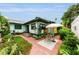 Charming backyard with brick pavers, lush greenery, and a patio area with table and chairs for outdoor enjoyment at 214 Scotland St, Dunedin, FL 34698