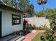 Charming backyard patio with colorful umbrella, lush plants and string lights creating a cozy outdoor space at 214 Scotland St, Dunedin, FL 34698