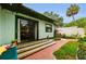 Charming backyard with wooden deck, sliding glass door, and lovely brick-paved outdoor seating area at 214 Scotland St, Dunedin, FL 34698