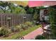 Landscaped backyard features a red brick path, flowers, fence and green foliage at 214 Scotland St, Dunedin, FL 34698