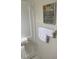 Bathroom corner with white tile, white towel and framed artwork at 214 Scotland St, Dunedin, FL 34698
