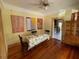 Dining room with hardwood floors, bright yellow walls and adjacent kitchen at 214 Scotland St, Dunedin, FL 34698