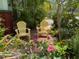 Cozy front porch with seating nestled amidst lush tropical foliage at 214 Scotland St, Dunedin, FL 34698