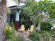Charming front porch with seating amidst lush tropical foliage at 214 Scotland St, Dunedin, FL 34698