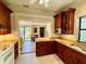 Well-equipped kitchen with warm wood cabinetry and granite countertops at 214 Scotland St, Dunedin, FL 34698