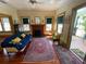 Cozy living room featuring hardwood floors, a fireplace, and access to a screened-in porch at 214 Scotland St, Dunedin, FL 34698