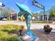 Outdoor art with a dolphin statue adding character to the town square; lush landscaping and clear skies at 214 Scotland St, Dunedin, FL 34698